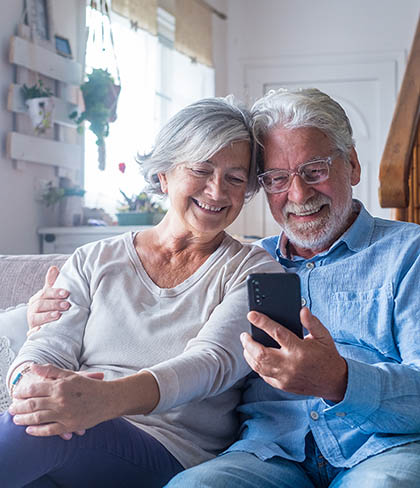 Older couple looking at a phone together, representing protection and insurance planning
