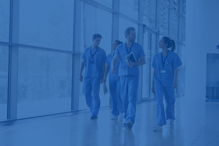 A group of nurses and healthcare workers walking through a corridor, smiling and looking supportive. The image has a blue overlay.
