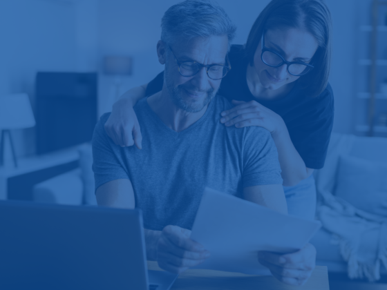 A couple reviewing and managing their budget with a blue overlay.