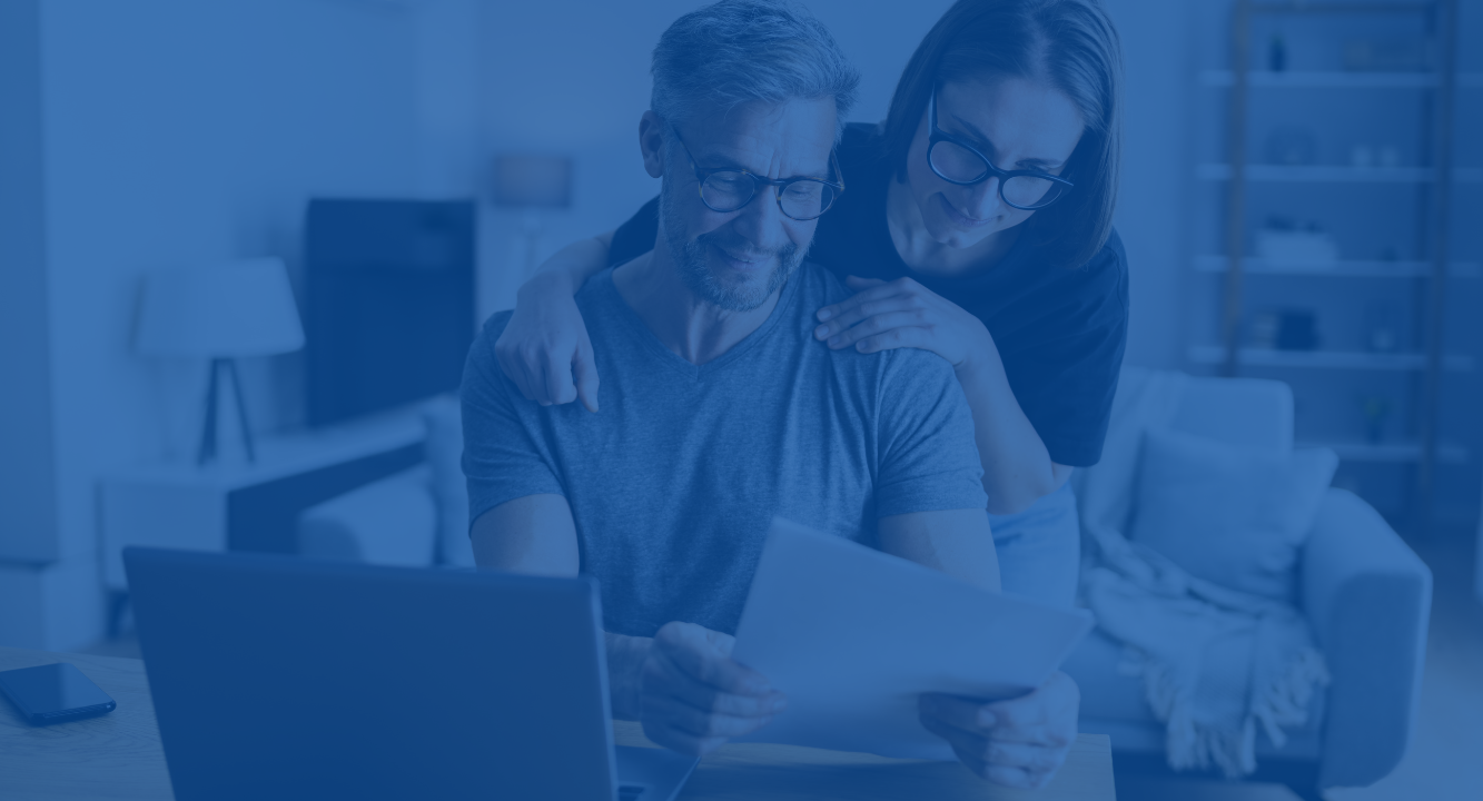 A couple reviewing and managing their budget with a blue overlay.