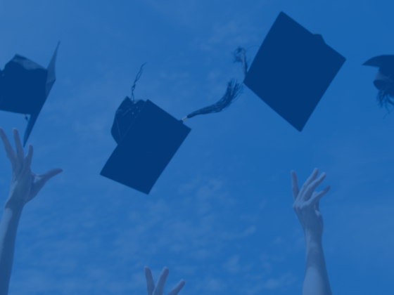 Recently Qualified Graduates celebrating by throwing their graduation caps into the sky with a blue overlay.