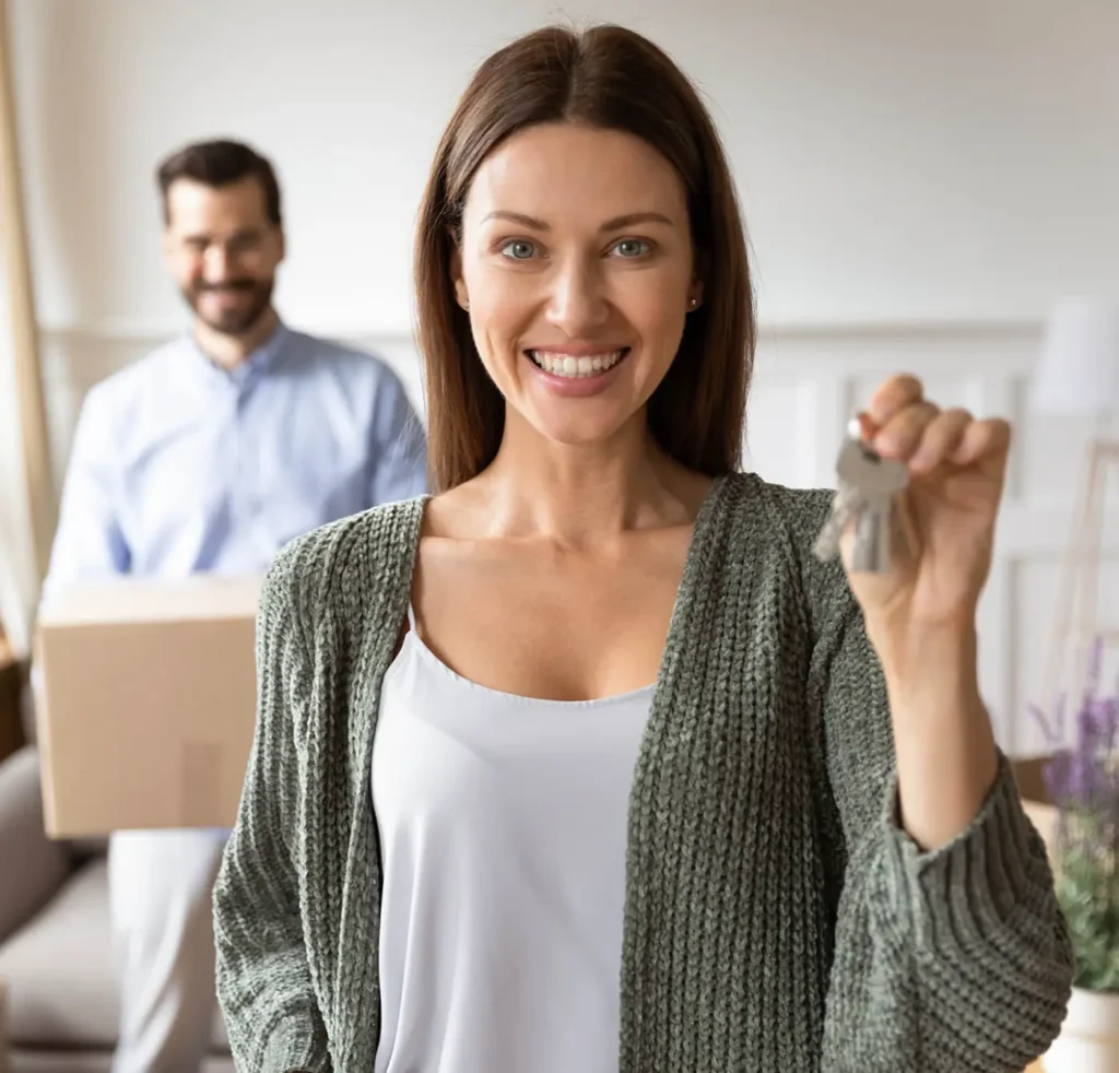 Smiling woman holding house keys, first-time buyer mortgages from Tony Flynn Mortgages