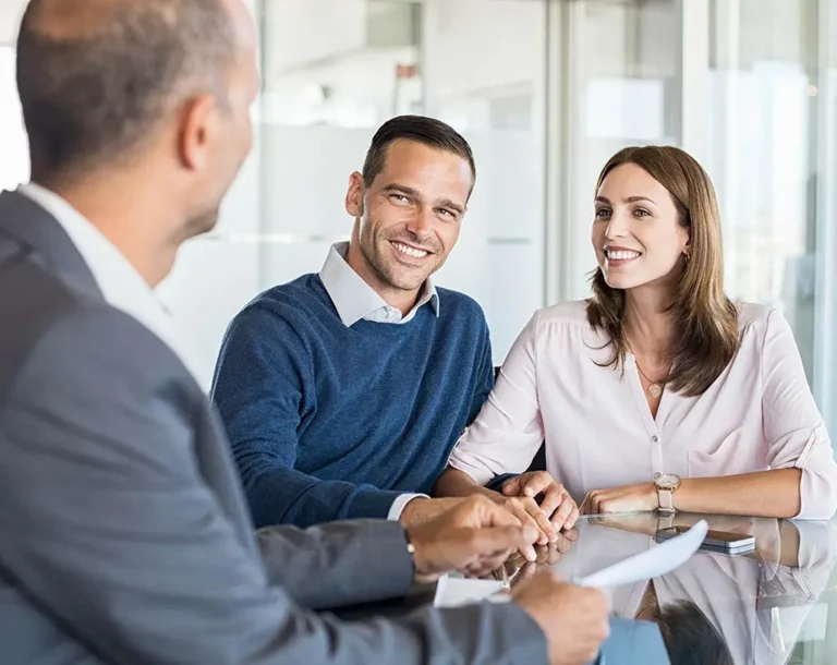 Smiling couple meeting a mortgage adviser to discuss poor credit mortgage options